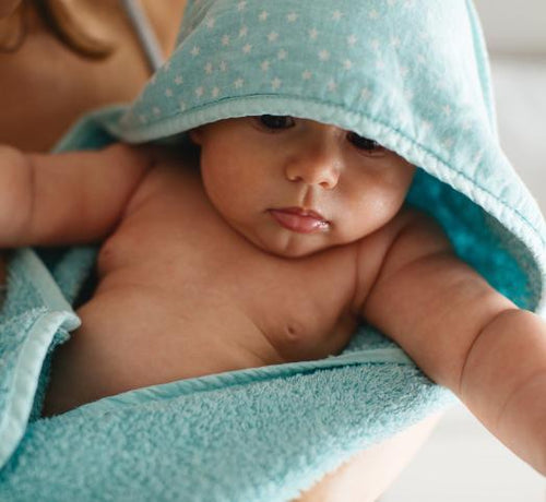 Un bebé con albornoz recién bañado y limpiado con jabones Mustela - Mustela España - 1
