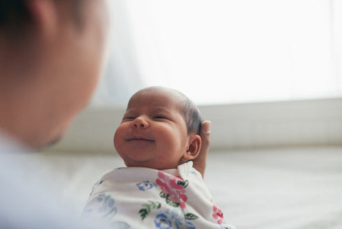 Bebé de unos 0 a 3 meses cogido entre los brazos de su padre sonriendo. - Mustela España - 1