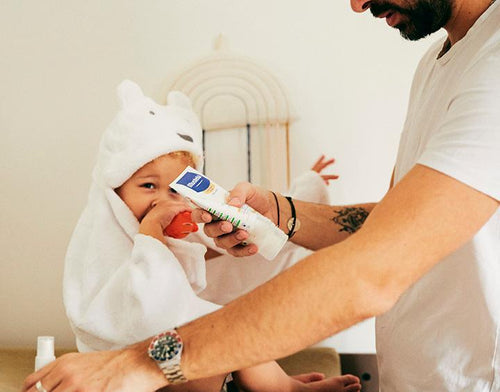 Un padre pone crema hidratante a su niño con piel seca - Mustela España - 1