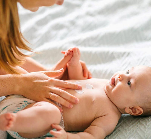 Una mamá aplicando una crema emoliente a su bebé con piel atópica. - Mustela España - 1