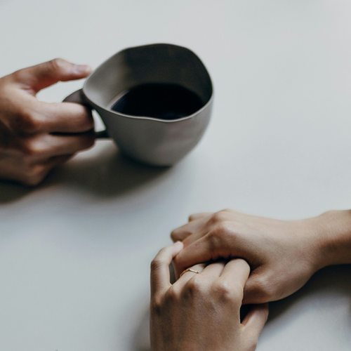 Mujer agarrándose las manos y un café - Mustela España - 1