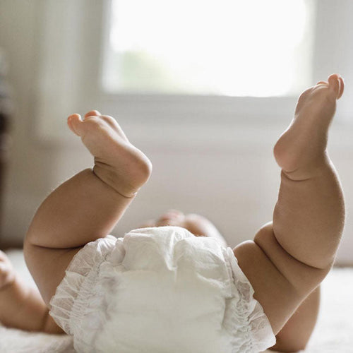 Bebé con los pies en alto preparado para darle un masaje. - Mustela España - 1