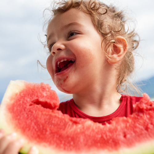 Una niña pequeña comiéndose una raja de sandia  - Mustela España - 1
