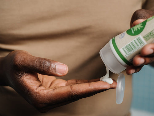 Padre aplicándose crema hidratante bio Mustela en la mano, ideal para toda la familia. - Mustela España - 4