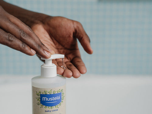 Padre aplica un poco de Gel 2 en 1 familiar para cabello y cuerpo en sus manos. - Mustela España - 4