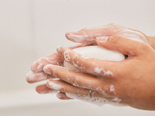 Una madre limpia con el jabón hidratante para manos, cara y cuerpo la piel seca de su bebé. - Mustela España - 4