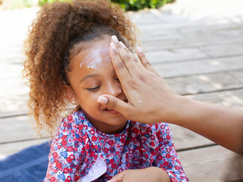 Una madre aplica crema solar en la cara de su niña.  - Mustela España - 4