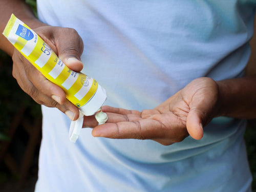 Un padre está vertiendo crema solar en su mano - Mustela España - 6