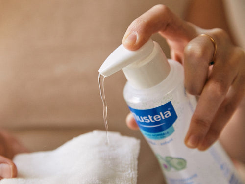 Madre aplica el agua limpiadora de Mustela en una toallita reutilizable de bebé con el dosificador fácil - Mustela España - 4