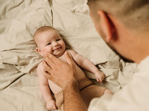 Un padre está aplicando la crema Stelatopia+ antipicor de Mustela en la cara de su bebé con piel atópica - Mustela España - 6