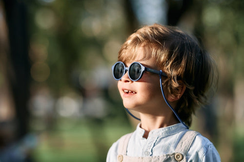 Bebé entre 1 y 2 años disfruta de un día soleado en el parque con las gafas de sol aguacate de Mustela by Parafina en color azul.  - Mustela España - 3