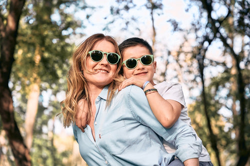 Una madre juega con su hijo en la montaña y llevan gafas de sol ecológicas de Mustela en color verde para proteger sus ojos. - Mustela España - 8